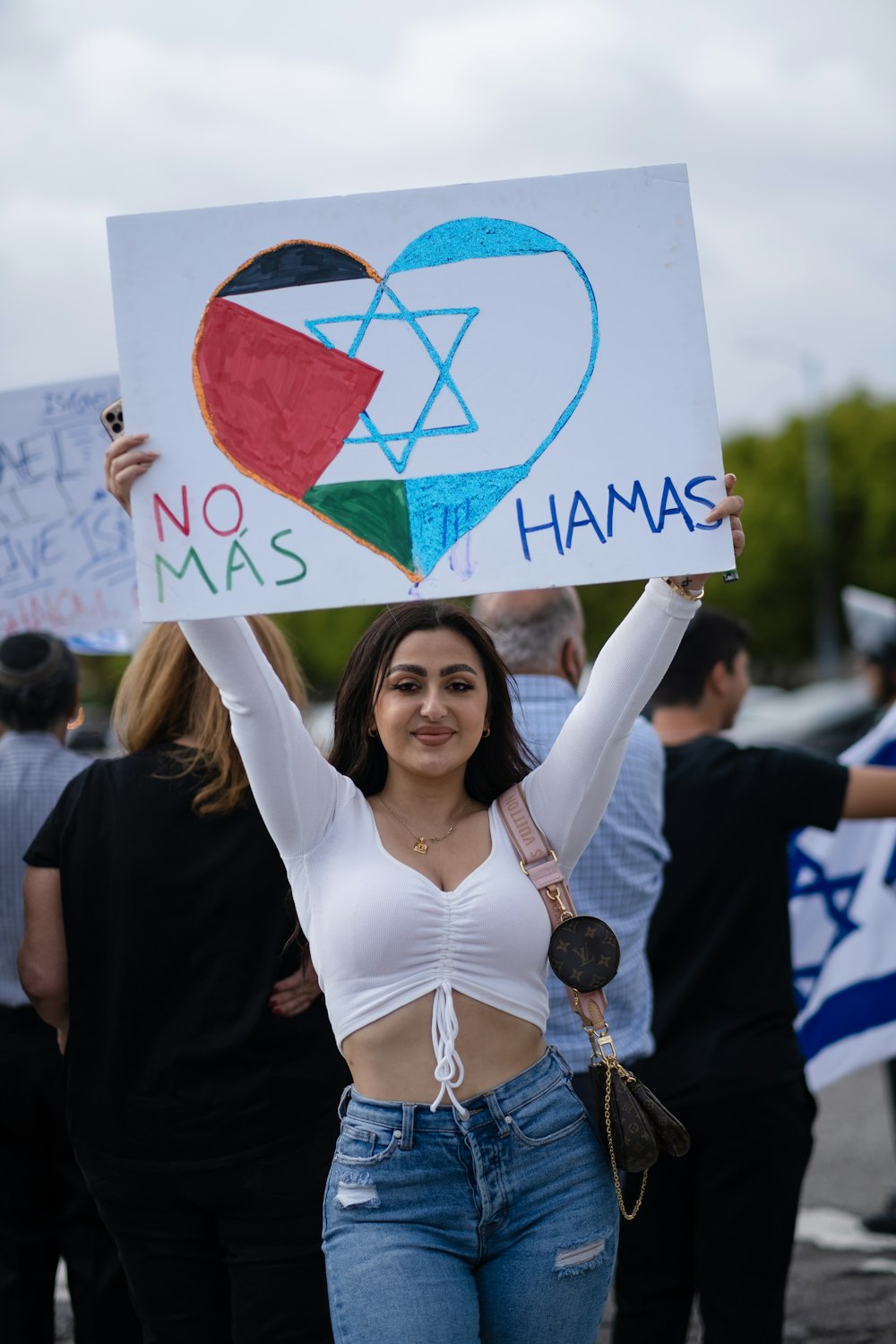 woman in white v neck shirt holding white and red banner