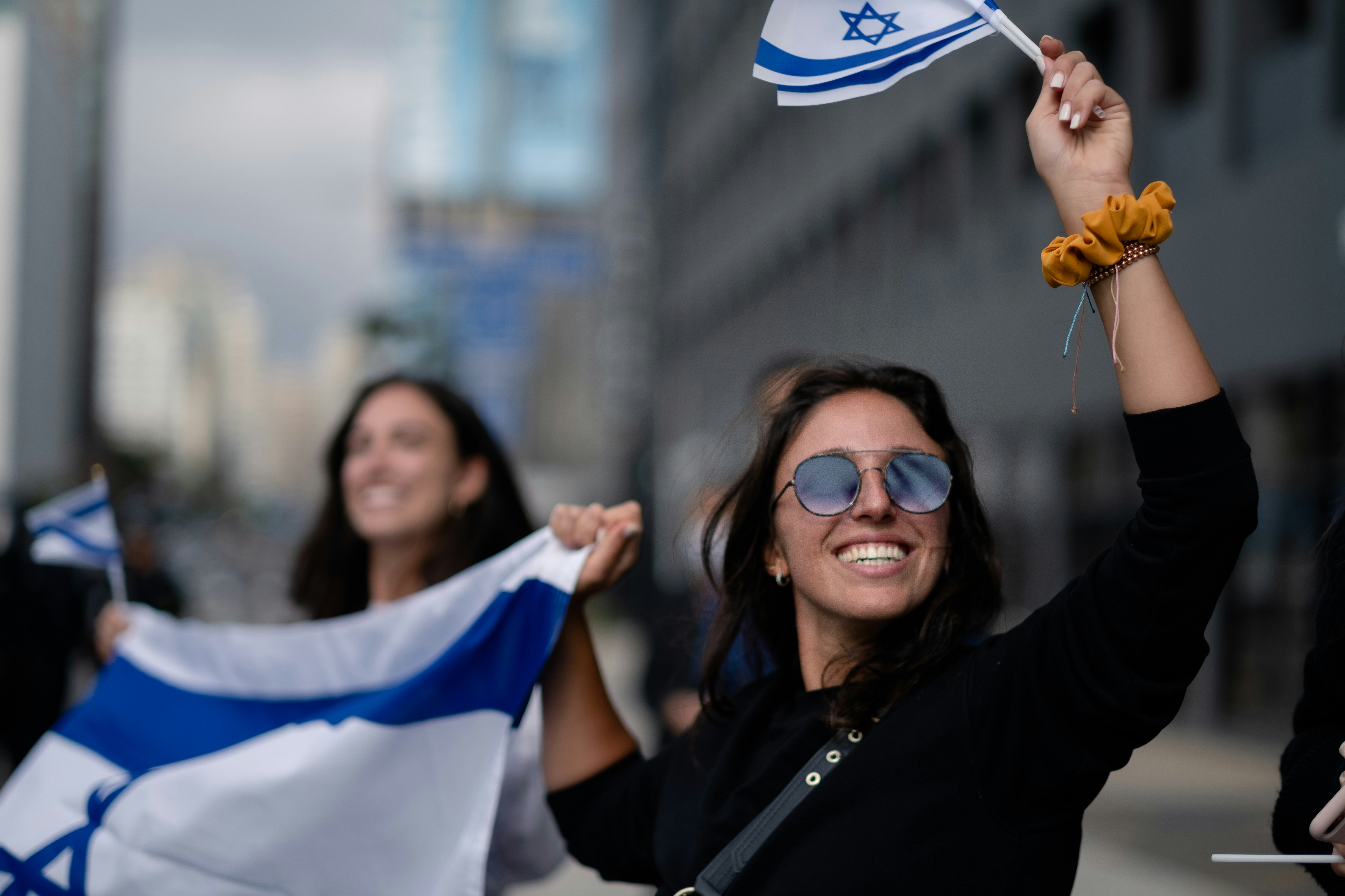 woman in black long sleeve shirt holding white and blue flag