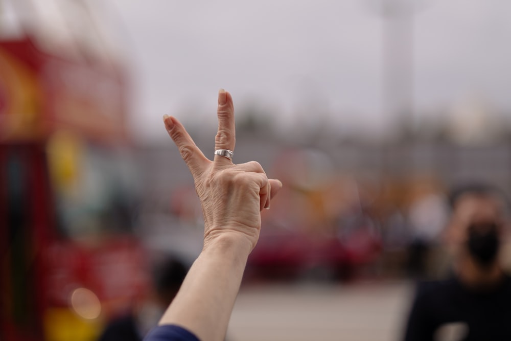 person in blue long sleeve shirt raising right hand