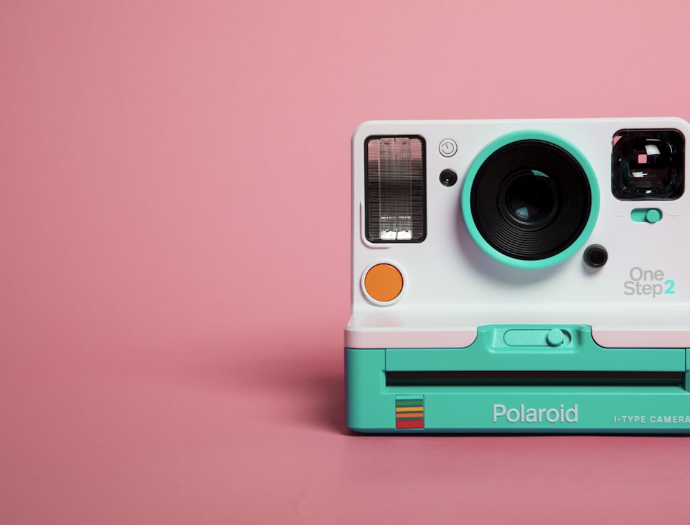 teal and white polaroid camera