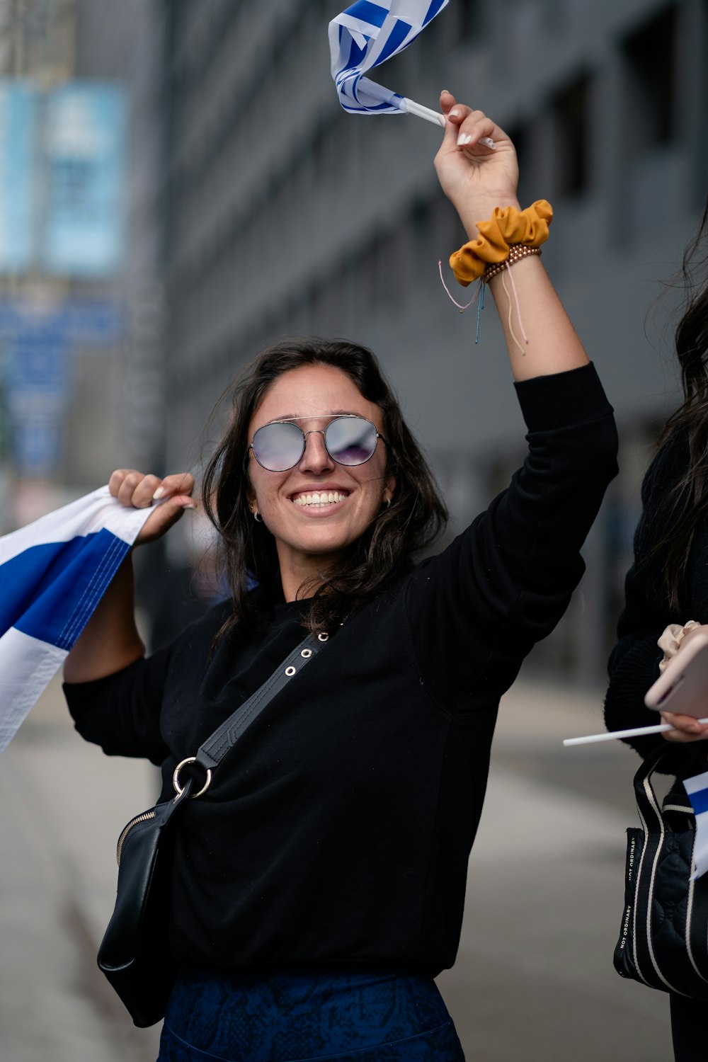 woman in black jacket wearing sunglasses smiling