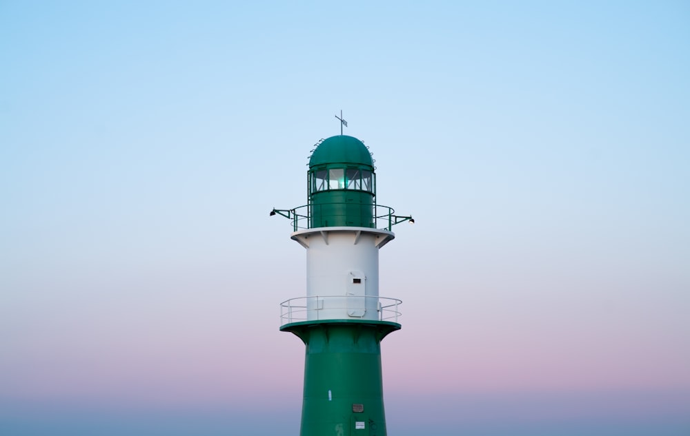 Faro verde y blanco bajo el cielo blanco durante el día