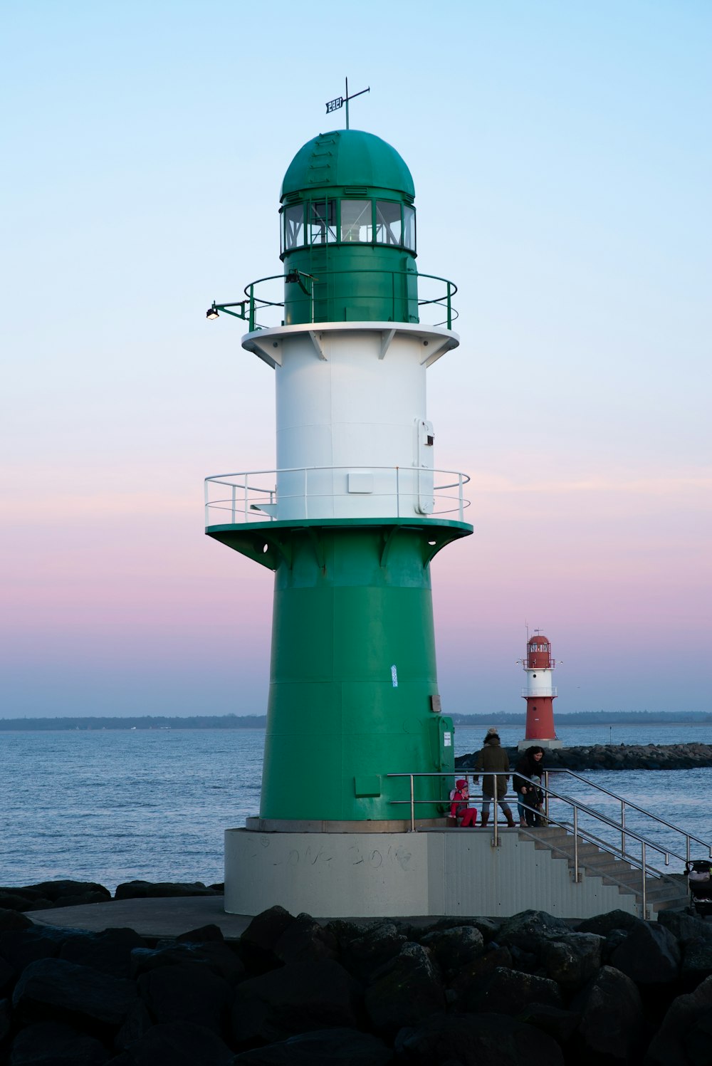 white and green lighthouse on sea during daytime