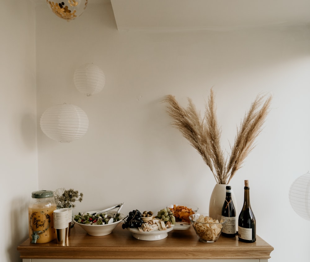 brown wheat on white ceramic bowl beside bottles on brown wooden table