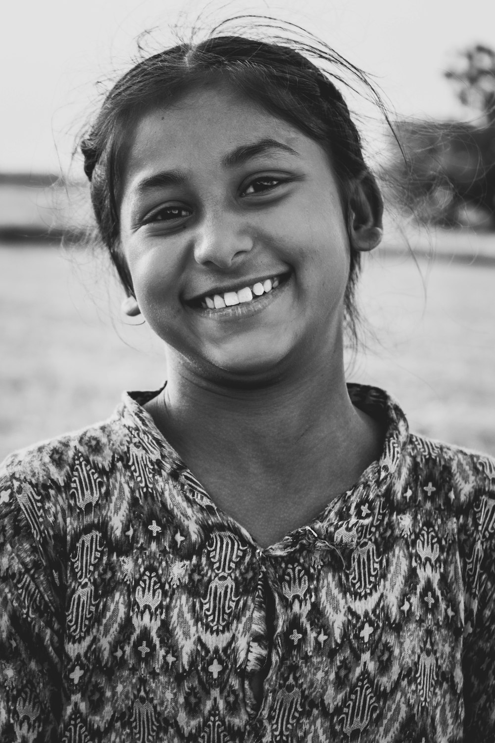 woman in black and white floral shirt smiling