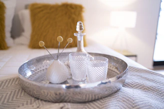 A beautifully set hotel room tray with gourmet dishes and a fresh flower vase.
