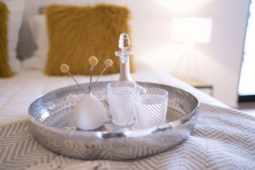 A beautifully set hotel room tray with gourmet dishes and a fresh flower vase.
