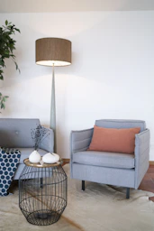 gray and brown sofa chair beside white and black table lamp