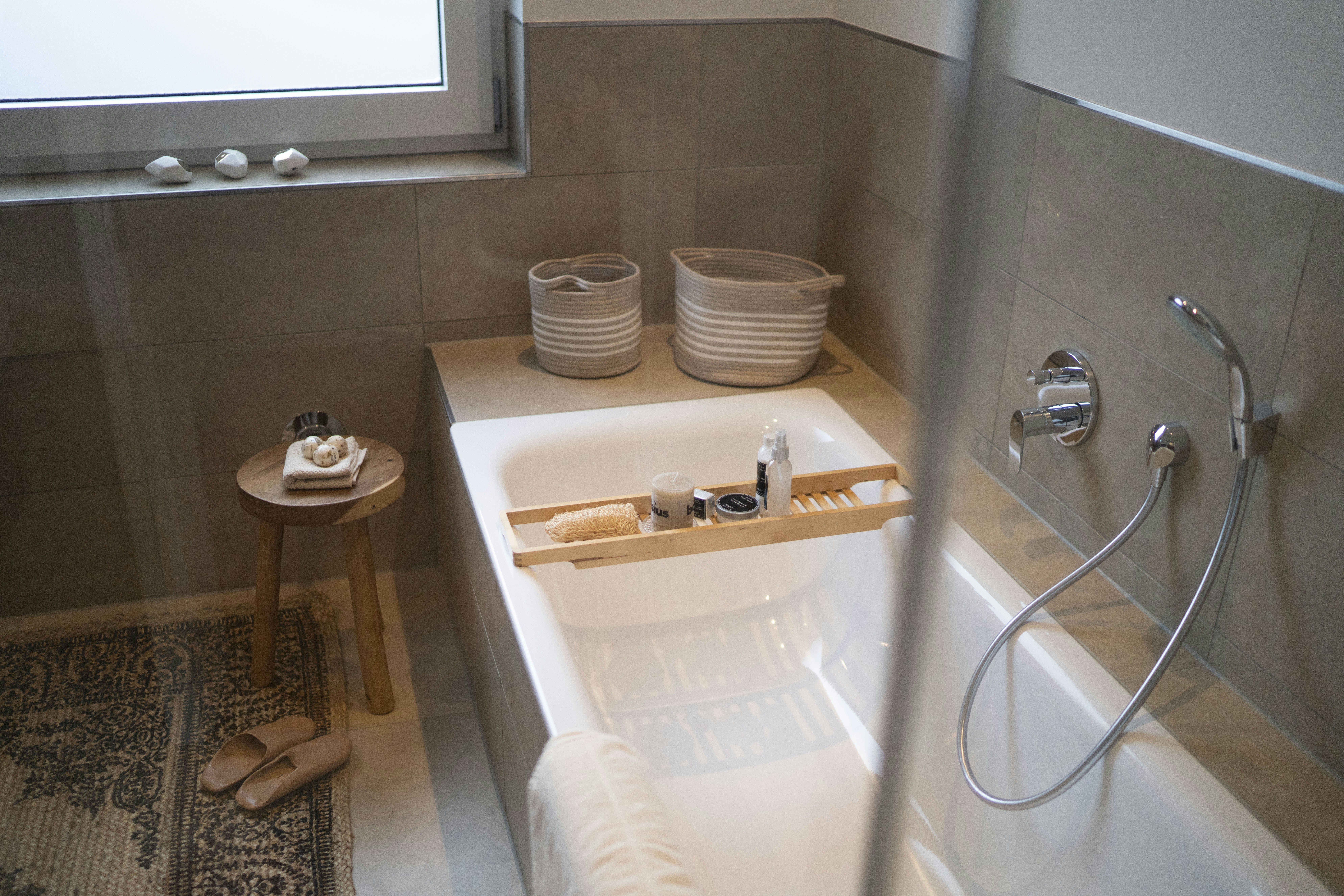 Kamar mandi hotel dengan bathtub bersih, ubin putih, pencahayaan terang, suasana spa mewah
