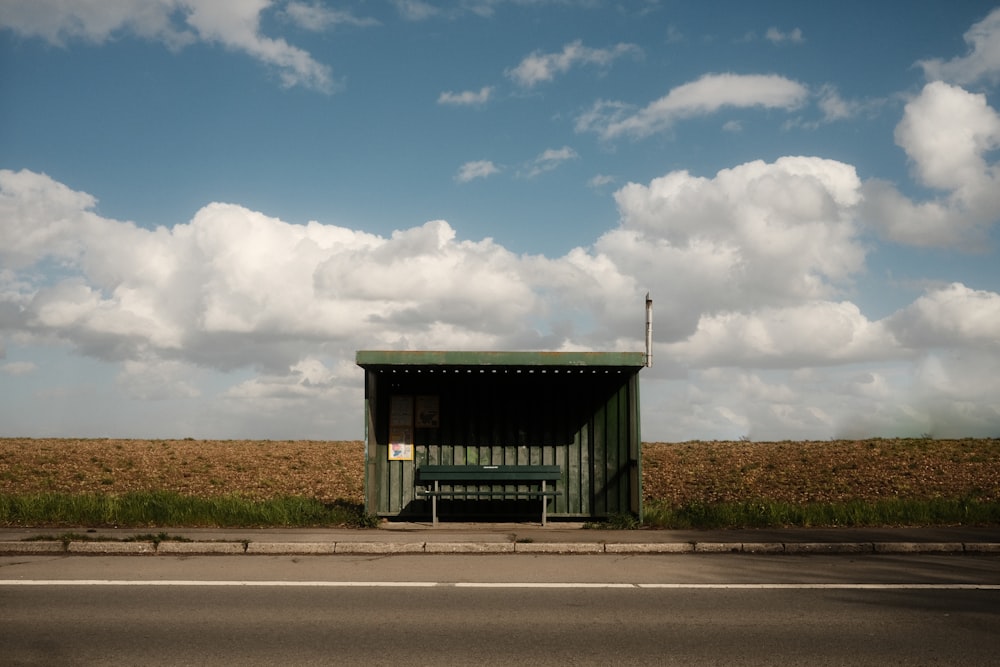 casa di legno grigia e bianca vicino alla strada sotto nuvole bianche e cielo blu durante il giorno