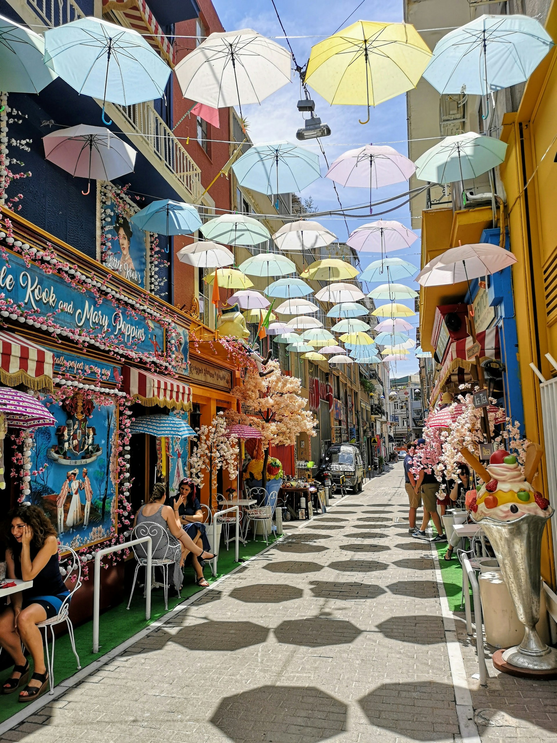 people sitting on chairs under umbrella during daytime