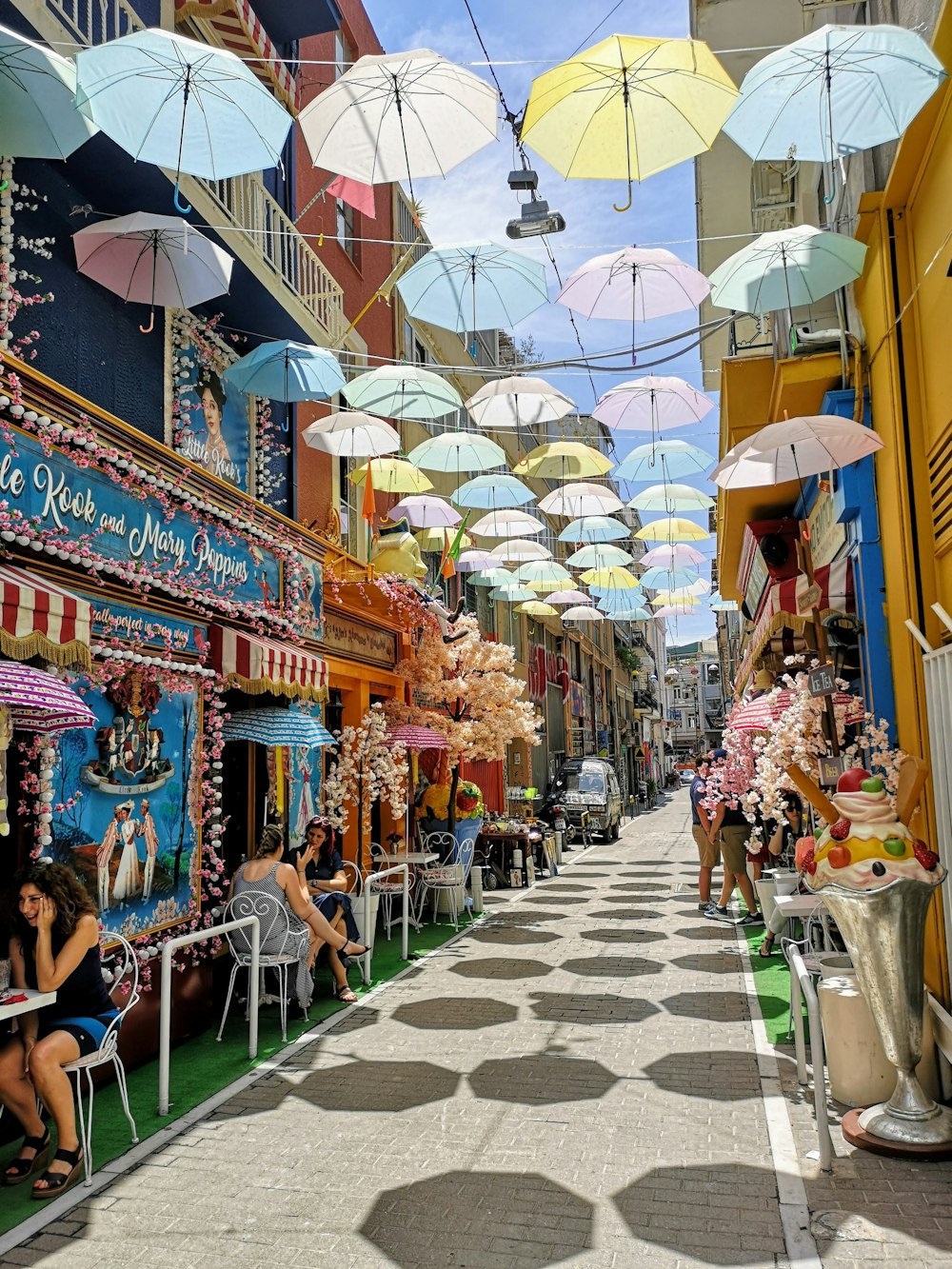 pessoas sentadas em cadeiras sob o guarda-chuva durante o dia