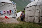 man in blue jacket standing near white tent during daytime