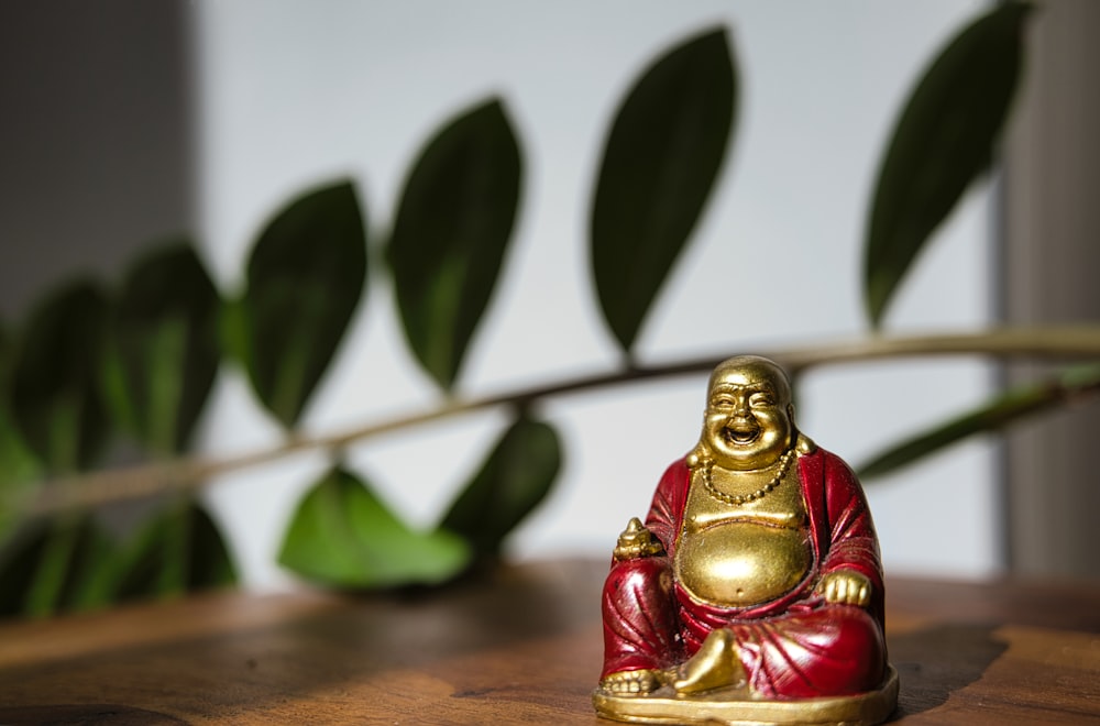 Statuetta di Buddha in oro su tavolo di legno marrone