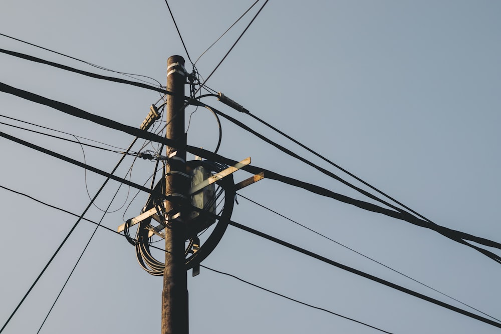 black electric post under blue sky during daytime