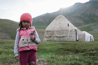 An elegant Uzbek girl smiling in a scenic landscape.