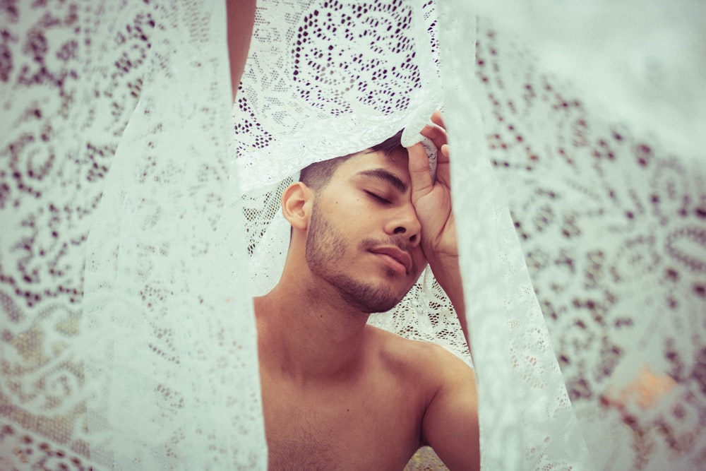 man lying on white floral textile