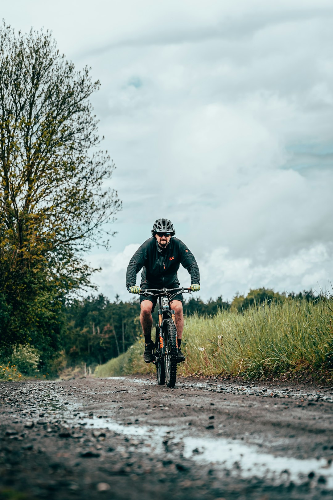 man in black and white bicycle helmet riding on black mountain bike on road during daytime