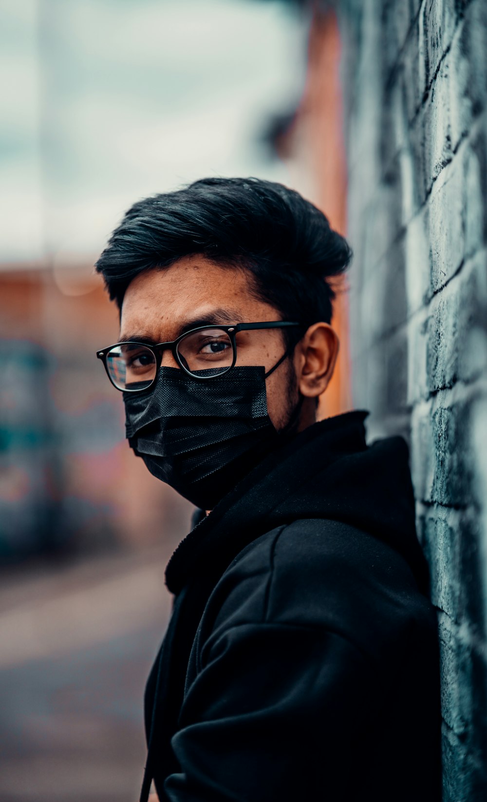 hombre con sudadera con capucha negra con gafas de montura negra