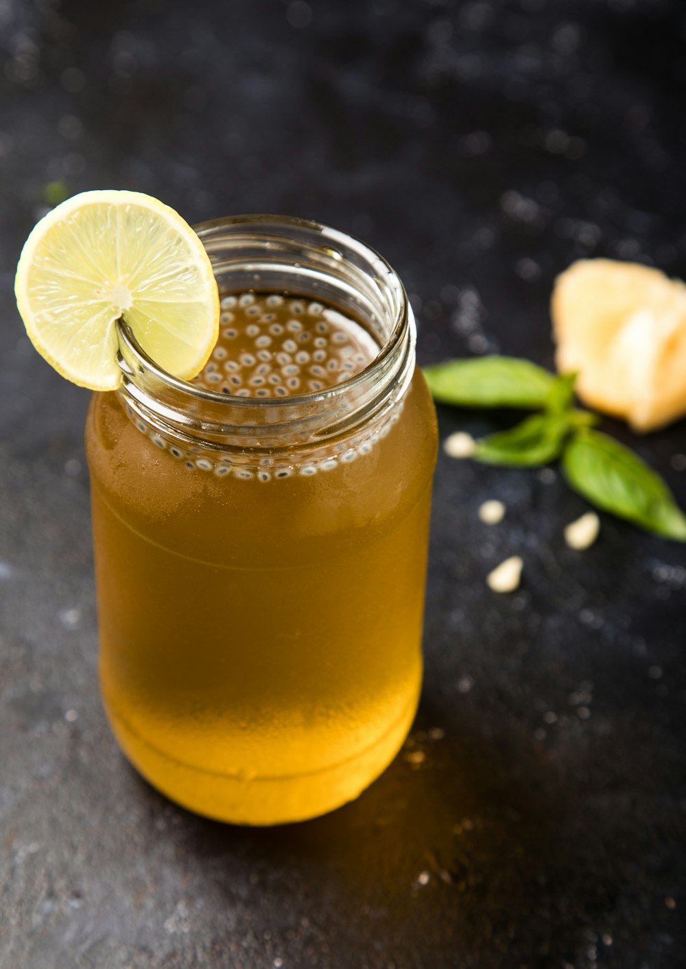 clear drinking glass with yellow liquid and sliced lemon