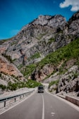 black car on road near mountain during daytime