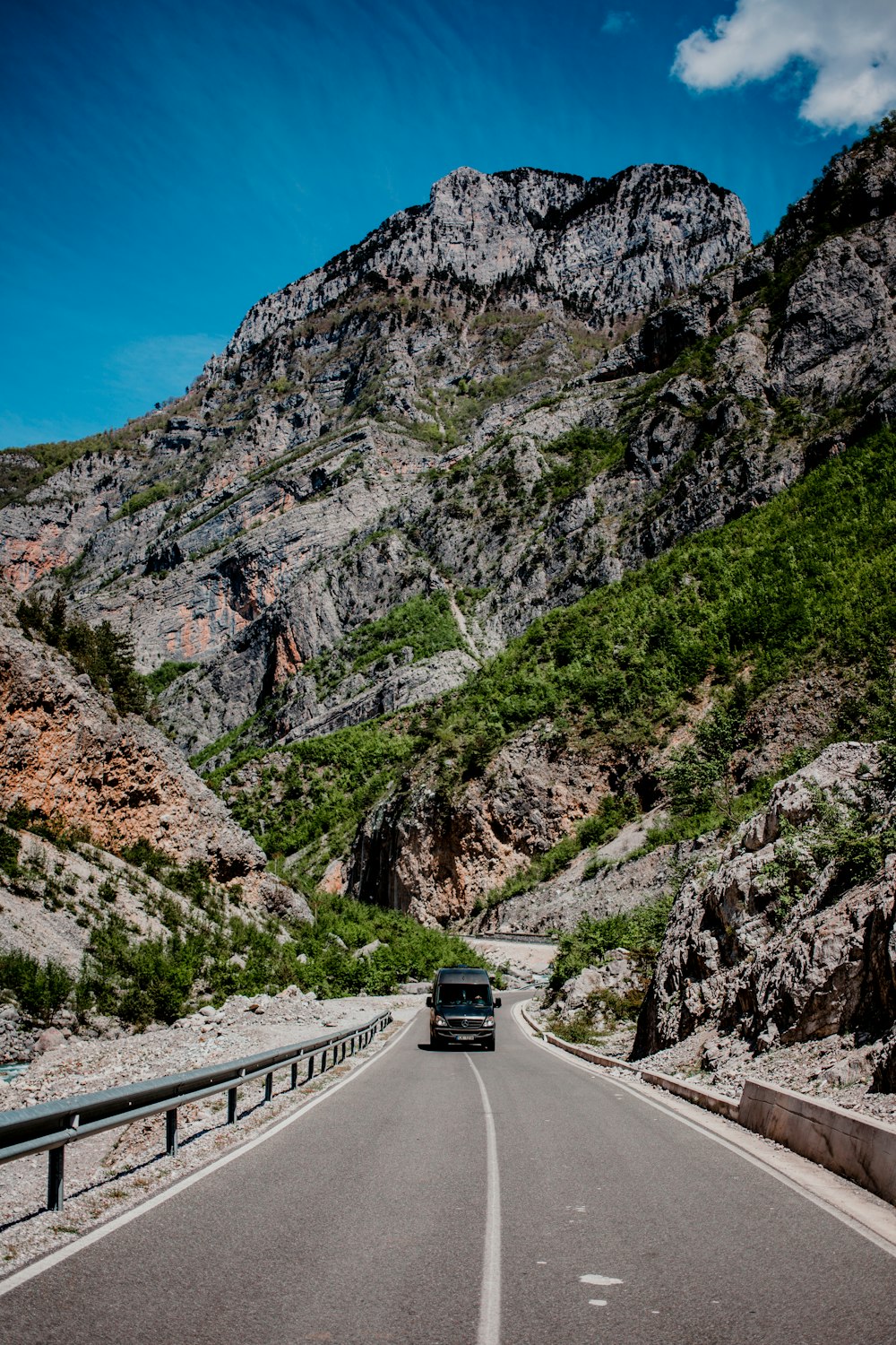 carro preto na estrada perto da montanha durante o dia