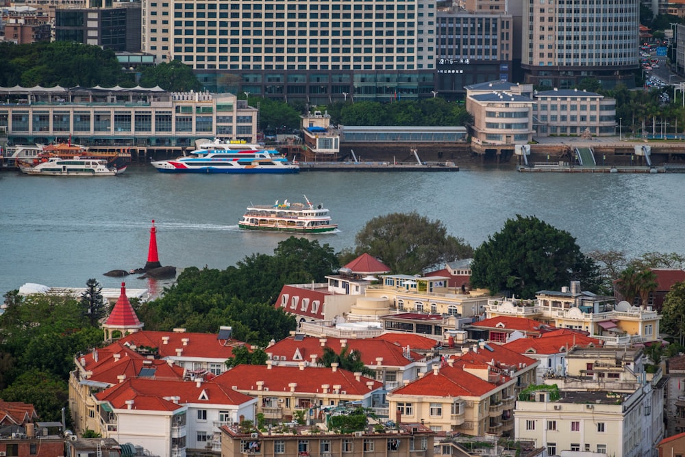 barco branco e azul na água perto de edifícios da cidade durante o dia