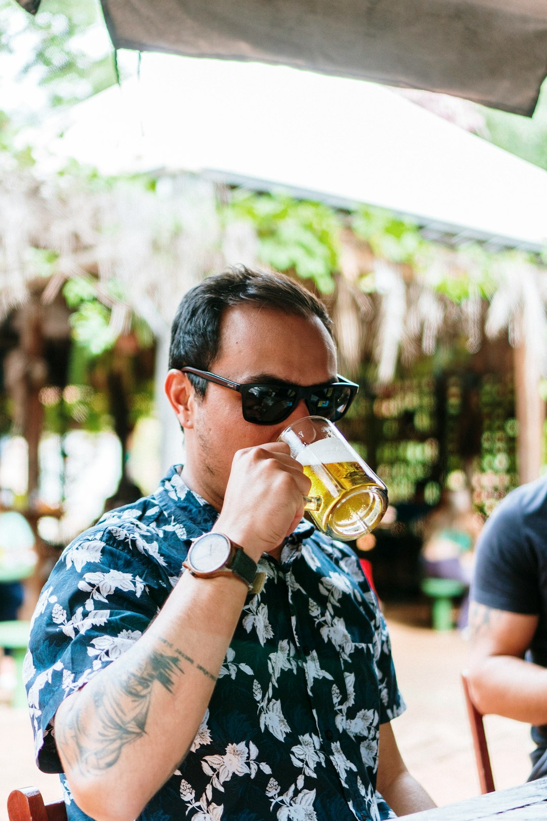 man in black and white floral shirt wearing black sunglasses