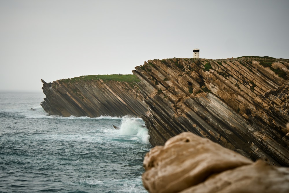 white lighthouse on cliff by the sea