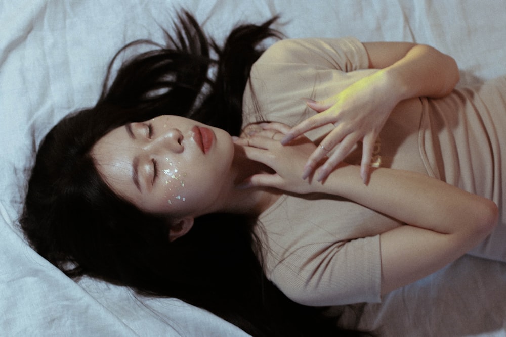 femme en t-shirt blanc allongée sur le lit