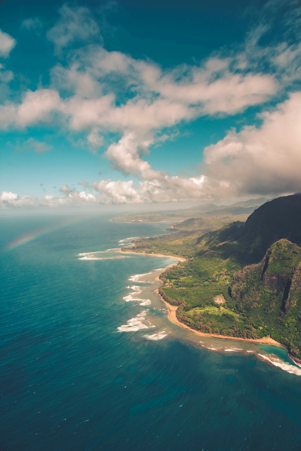 green trees on island under blue sky and white clouds during daytime