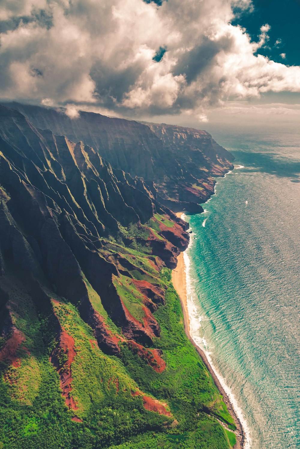 green and brown mountain beside body of water during daytime