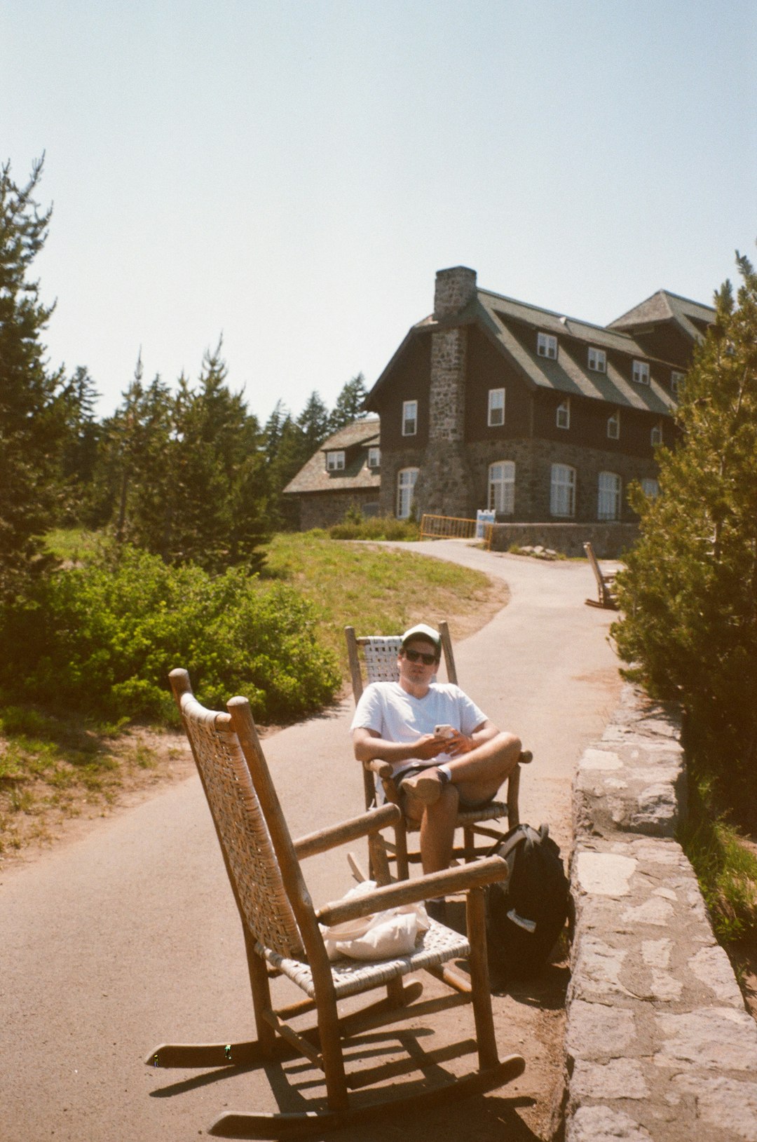 man in white t-shirt sitting on brown wooden bench