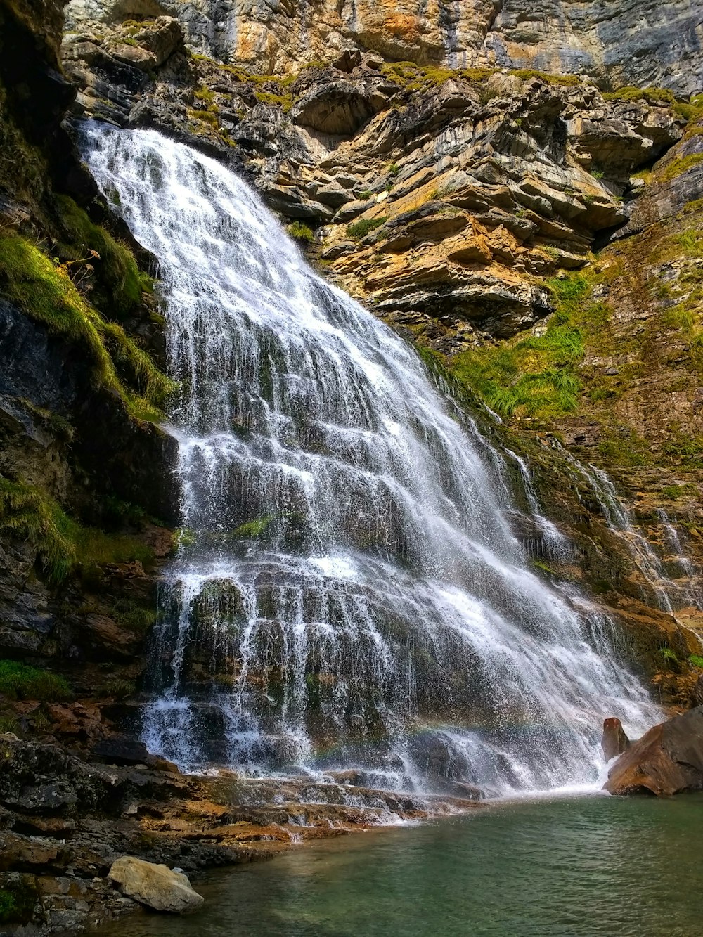 waterfalls on rocky mountain during daytime