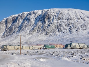 white and brown house near mountain under blue sky during daytime