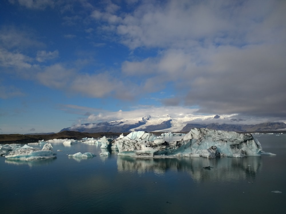 snow covered mountain near body of water under blue sky during daytime