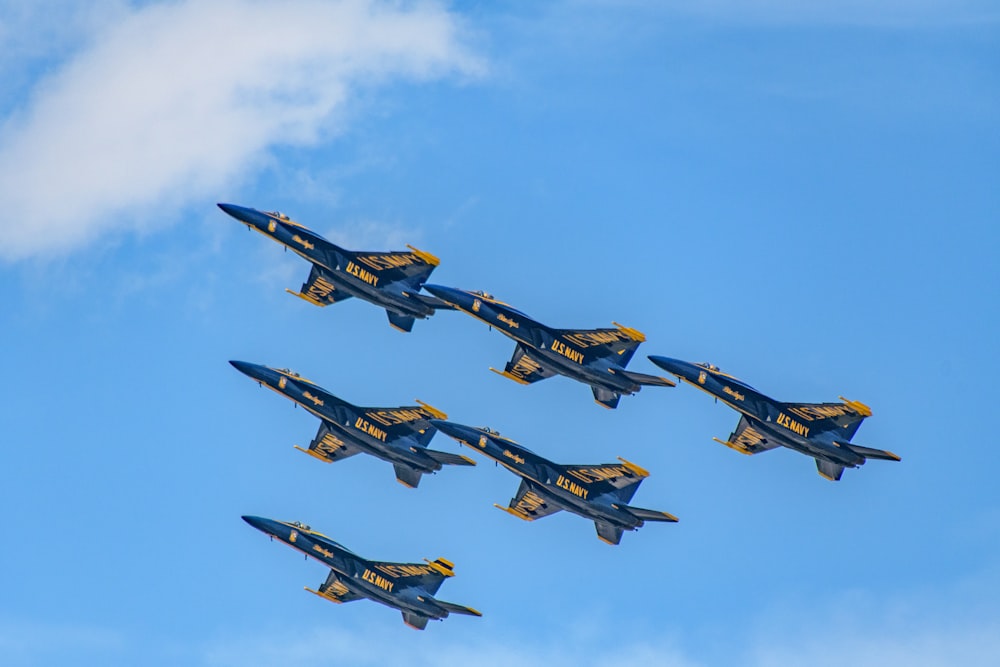 four black and yellow fighter planes in mid air during daytime