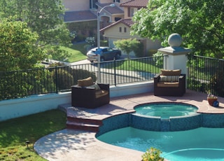 blue swimming pool near green trees during daytime