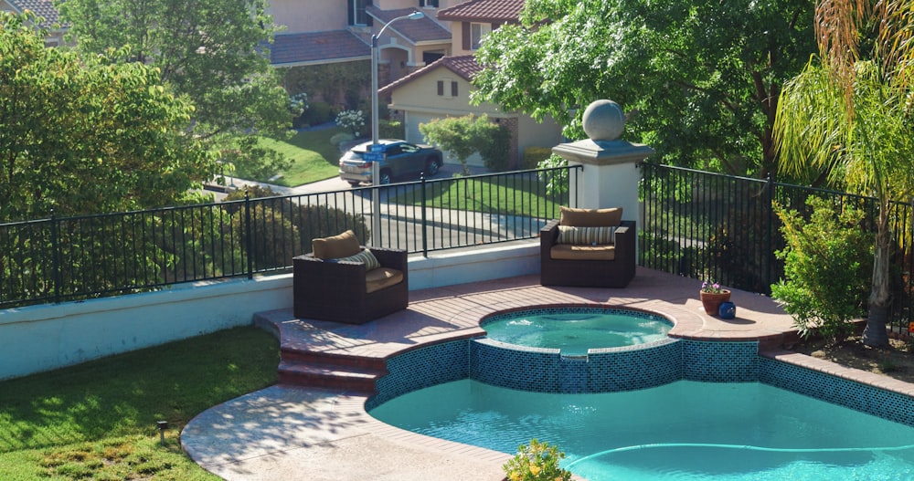 blue swimming pool near green trees during daytime