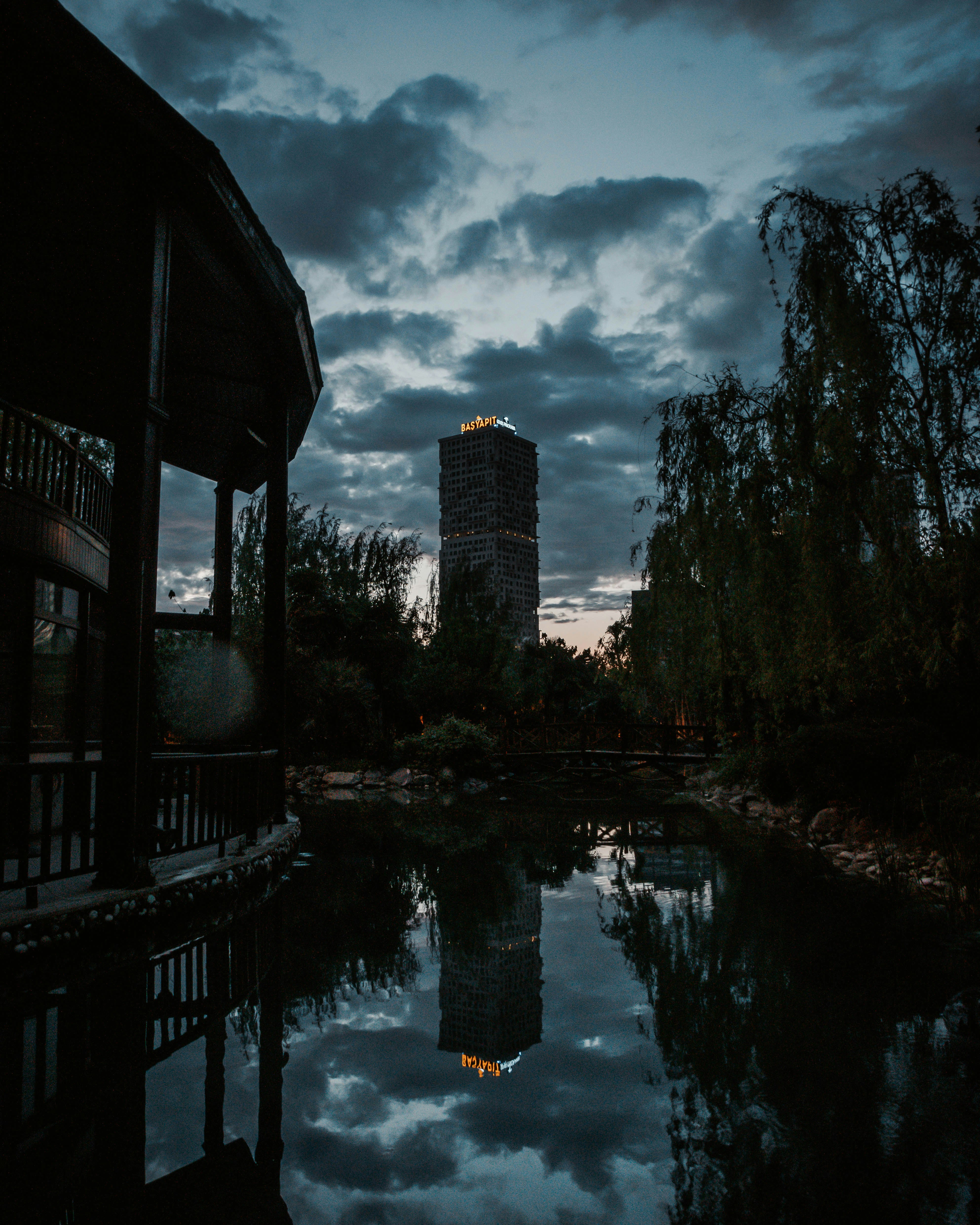 body of water between trees under cloudy sky during daytime