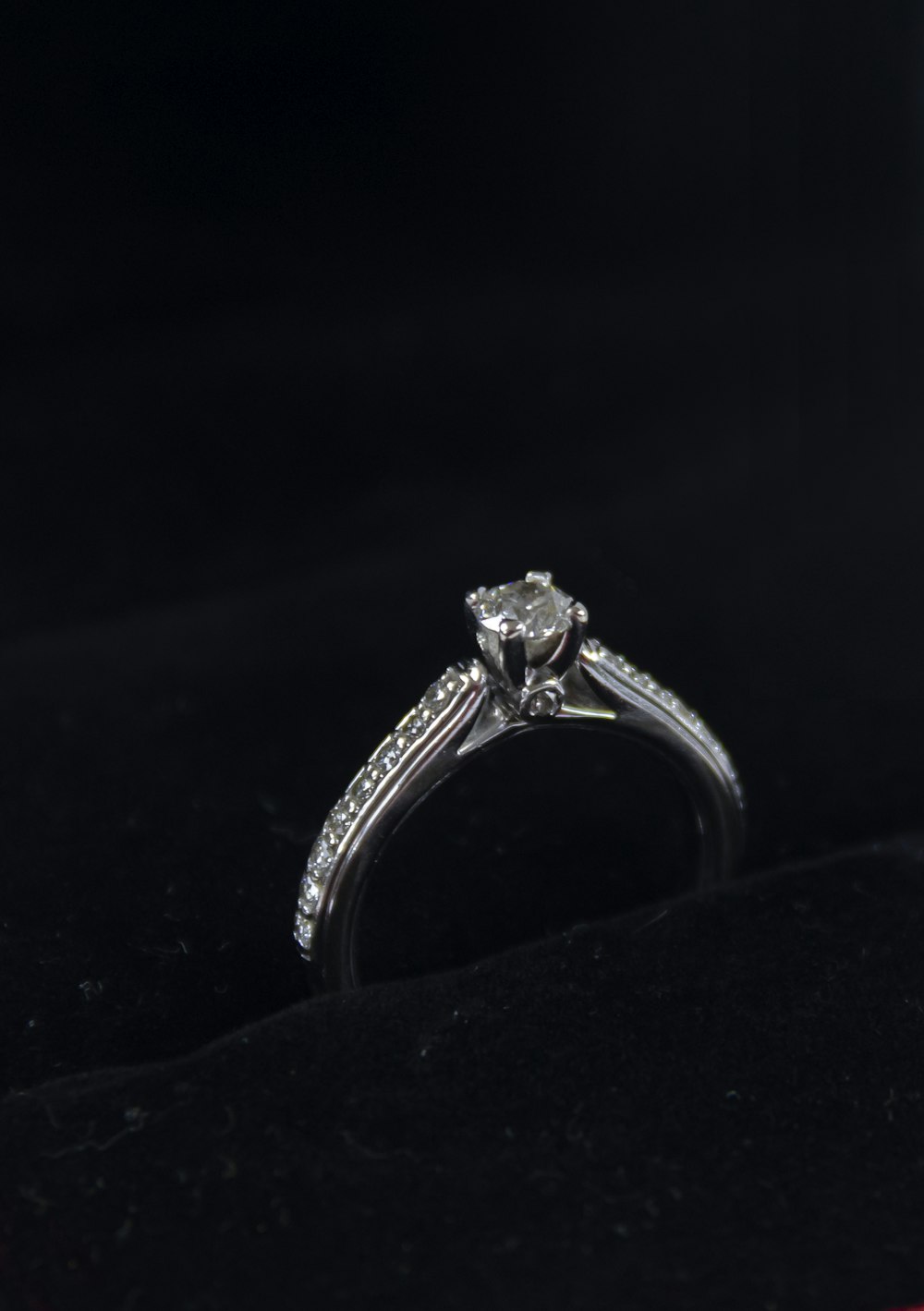 silver diamond ring on black textile