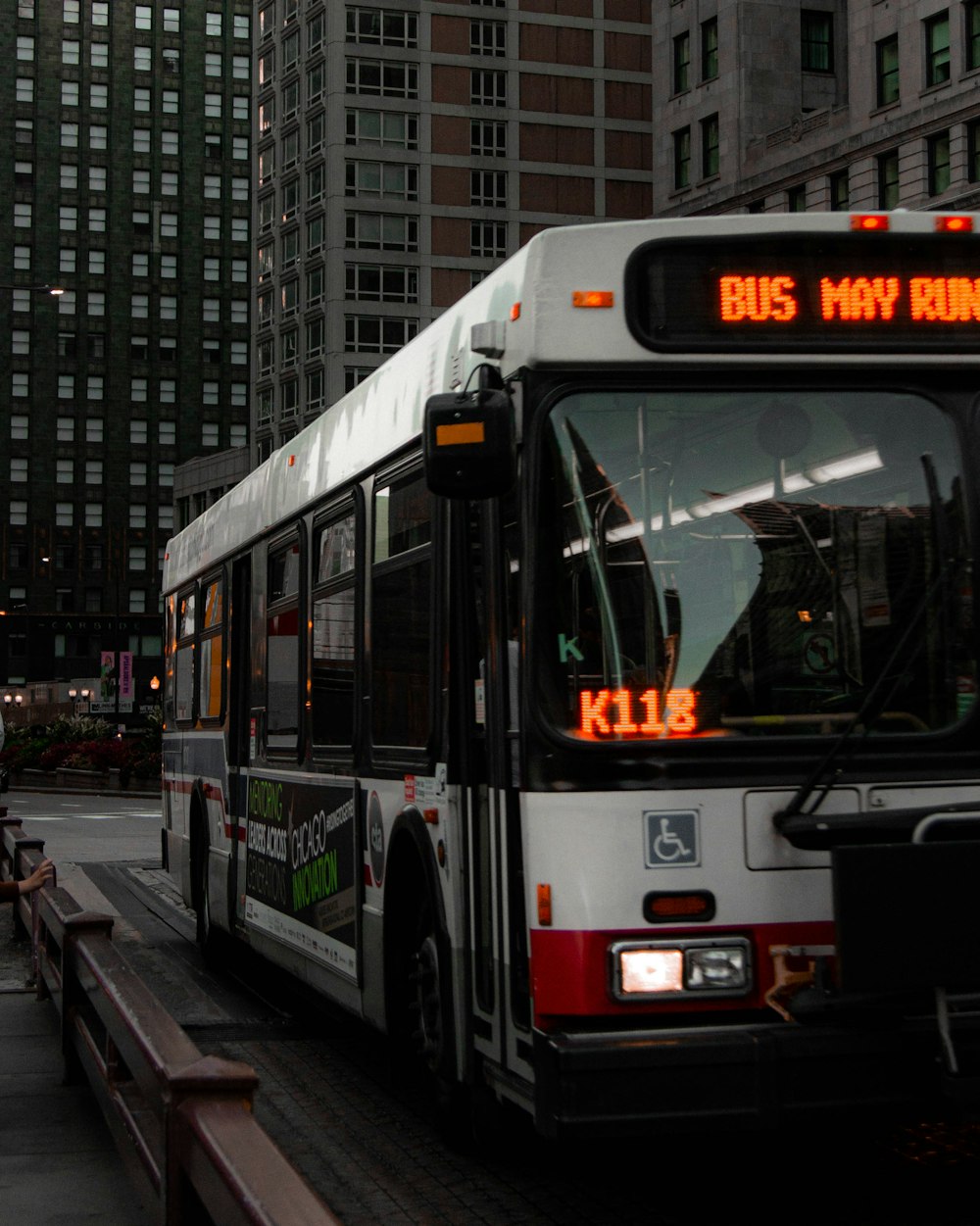 white and red bus on road during daytime