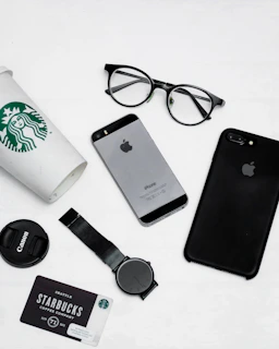 Flat lay of starstory accessories including minimalist black caps and soft purple gradient scarves on a clean white surface.