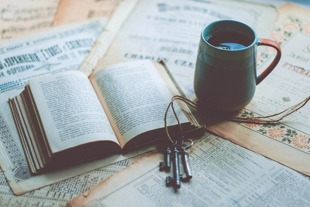 an open book and a pair of keys on a table