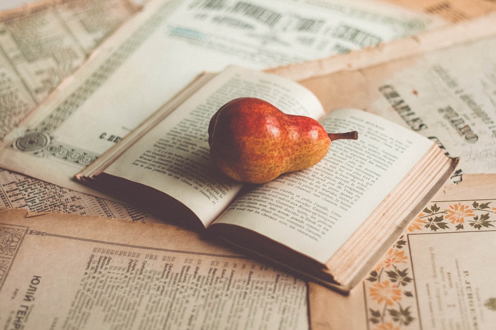 red apple on top of white book page