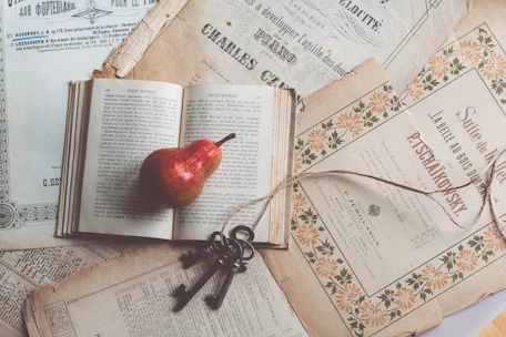 A vintage key resting on an open book with highlighted notes.