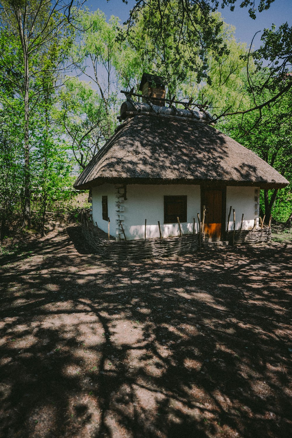 casa de madeira marrom e branca cercada por árvores verdes durante o dia