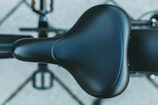 Side view of the Kikos stationary bike highlighting the adjustable seat and pedals.