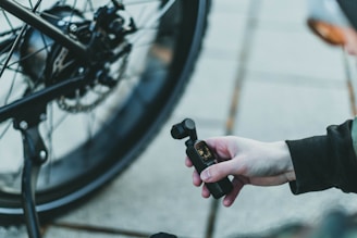 A behind-the-scenes shot showing a dad recording a funny cycling video for social media, with his bike in the background.