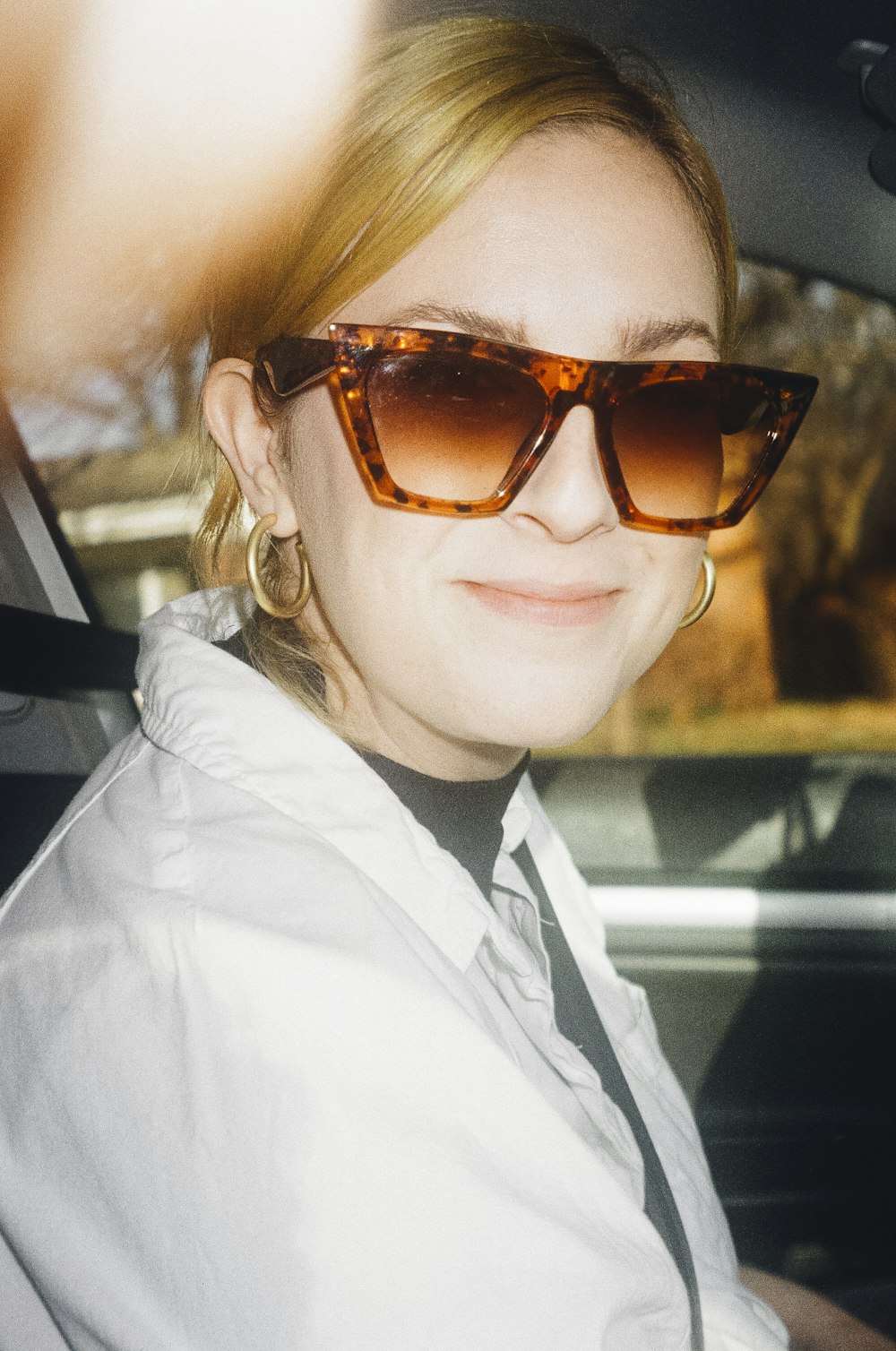 woman in white collared shirt wearing brown sunglasses